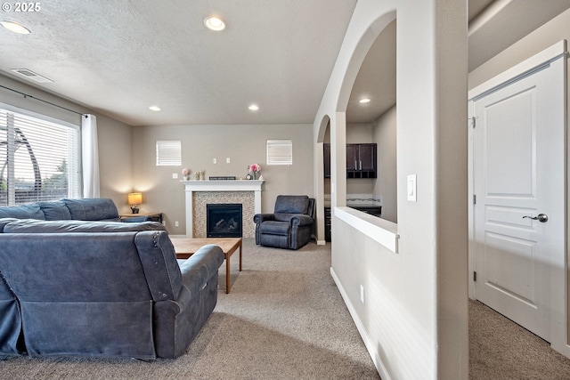 carpeted living room featuring a textured ceiling