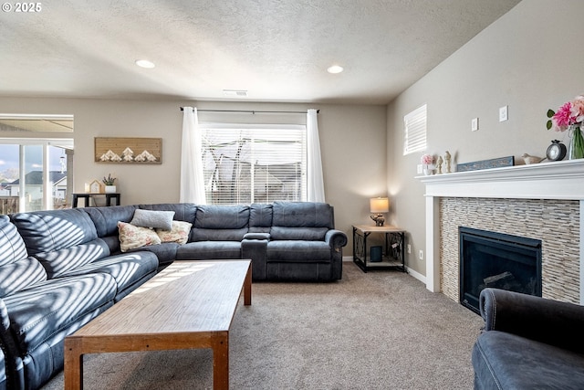 living room featuring plenty of natural light, a fireplace, a textured ceiling, and carpet floors