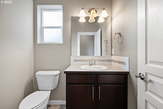 bathroom with vanity, toilet, and decorative backsplash