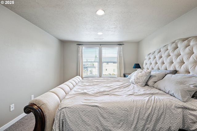 carpeted bedroom featuring visible vents, baseboards, and a textured ceiling