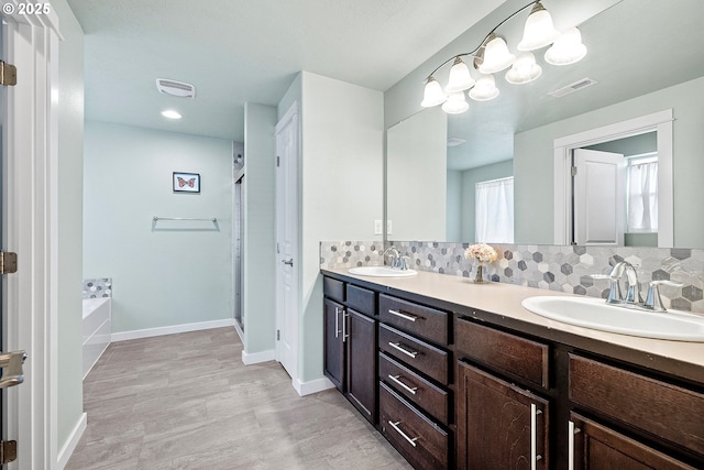 bathroom featuring vanity, backsplash, and separate shower and tub