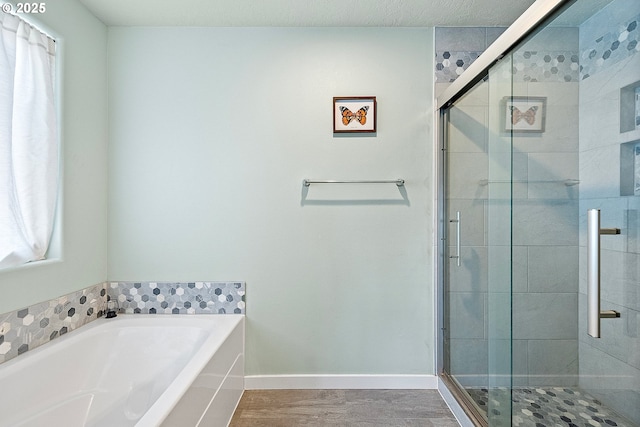 bathroom featuring wood-type flooring and separate shower and tub