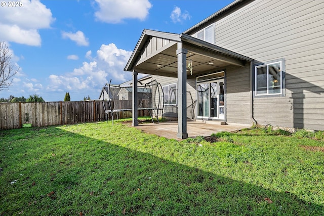 view of yard with a trampoline and a patio area