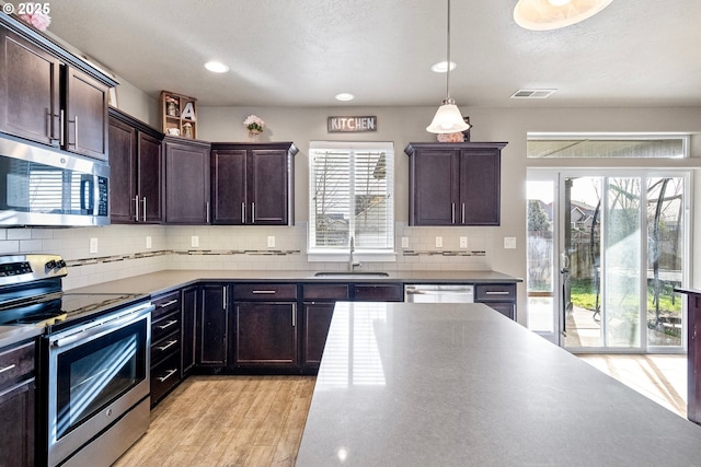 kitchen featuring pendant lighting, stainless steel appliances, sink, and plenty of natural light