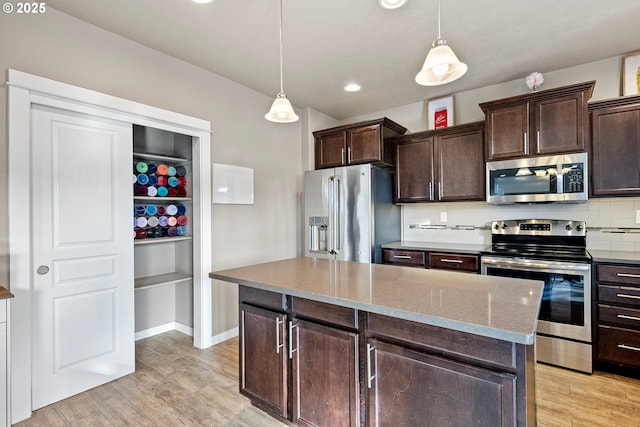 kitchen featuring backsplash, light wood-type flooring, and appliances with stainless steel finishes