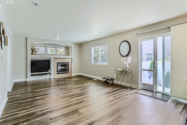 unfurnished living room featuring a fireplace, hardwood / wood-style floors, and a textured ceiling