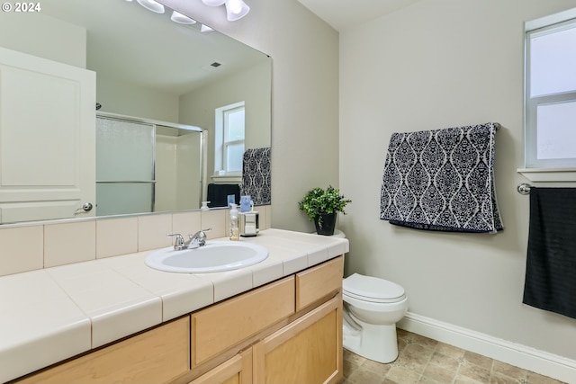 bathroom featuring vanity, toilet, and a shower with door