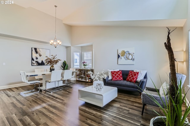 living room with high vaulted ceiling, dark hardwood / wood-style floors, and an inviting chandelier