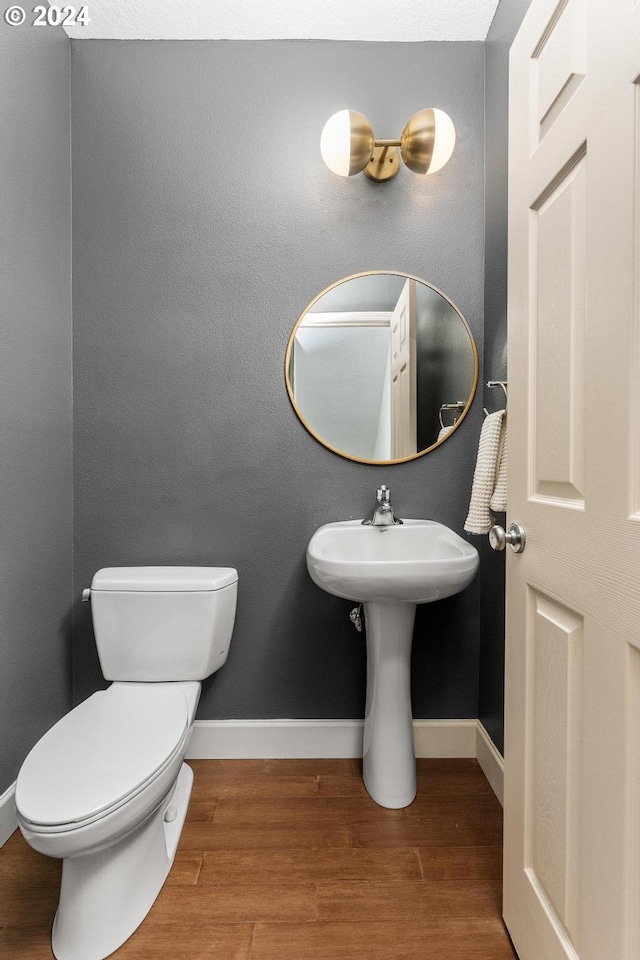 bathroom featuring wood-type flooring and toilet