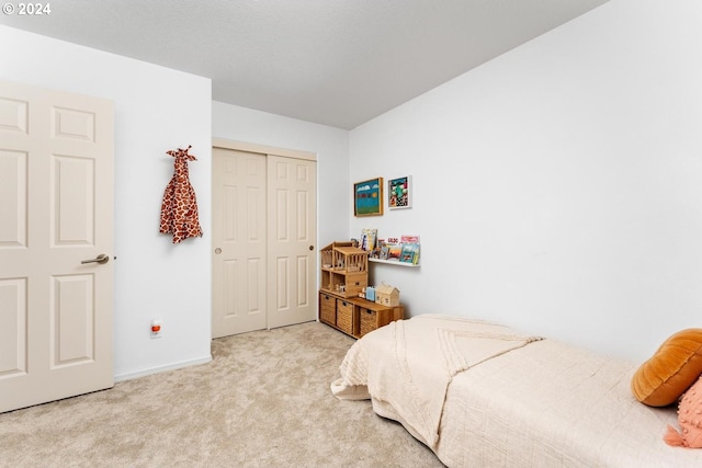 bedroom with light carpet and a closet