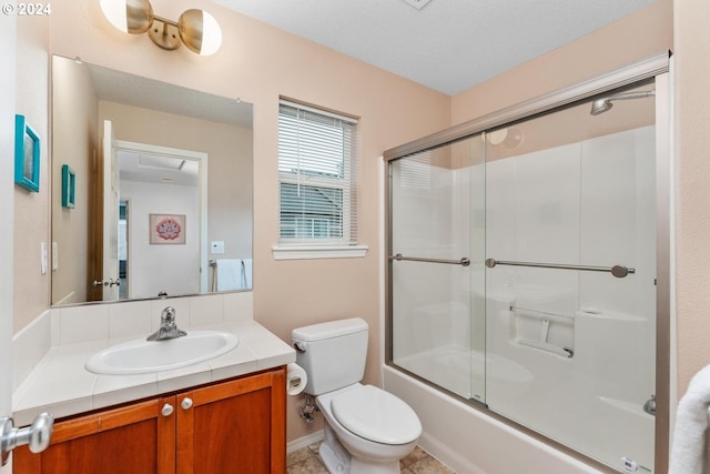 full bathroom featuring bath / shower combo with glass door, vanity, and toilet