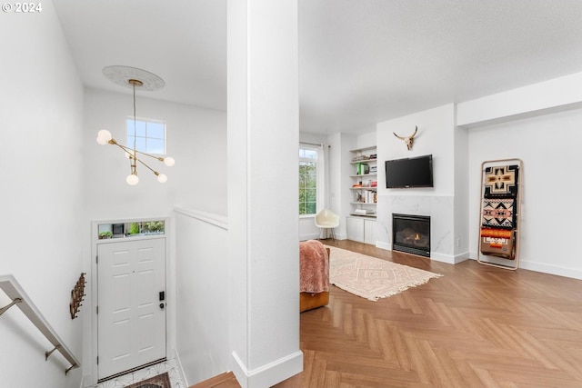 entryway with parquet floors and an inviting chandelier