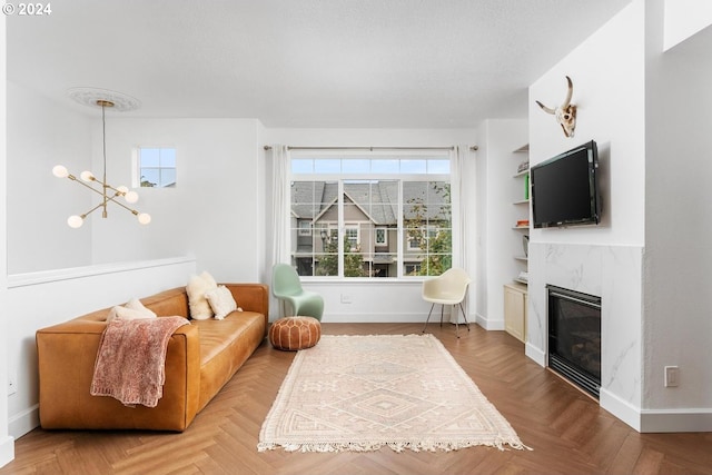 living room with light parquet flooring, plenty of natural light, a premium fireplace, and a notable chandelier