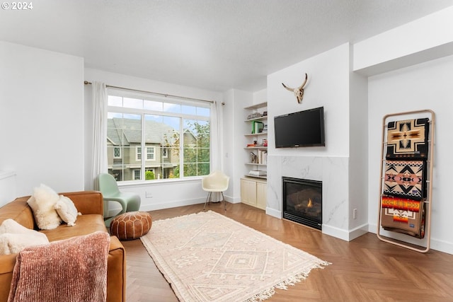 living room with built in shelves and a high end fireplace