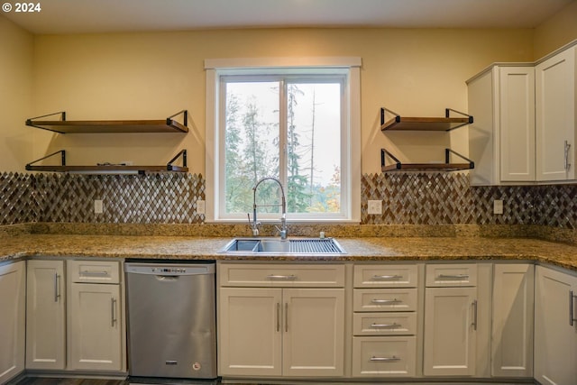 kitchen featuring white cabinetry, stainless steel dishwasher, sink, backsplash, and light stone counters