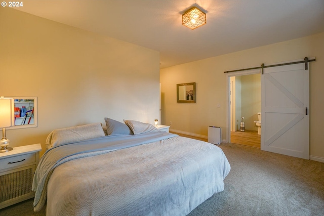 carpeted bedroom with ensuite bathroom, radiator heating unit, and a barn door