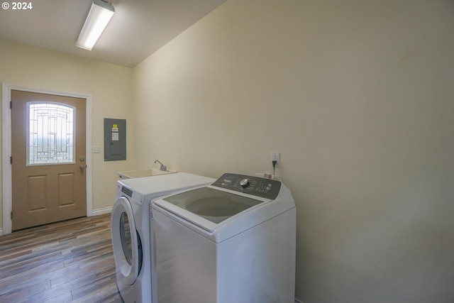 laundry room featuring sink, light hardwood / wood-style flooring, electric panel, and washer and dryer