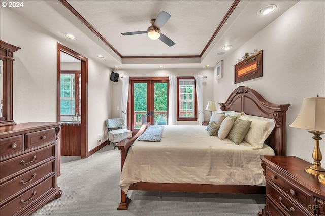 carpeted bedroom featuring french doors, ornamental molding, a tray ceiling, and ceiling fan