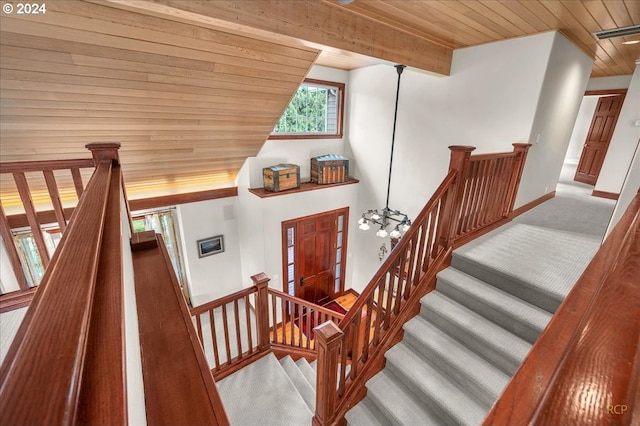 stairway featuring carpet, an inviting chandelier, and wooden ceiling