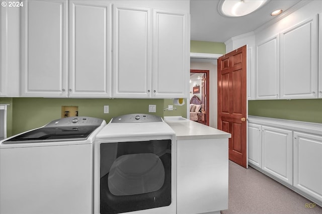 washroom featuring washing machine and clothes dryer and cabinets