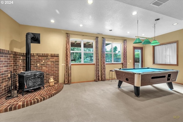 playroom with billiards, light carpet, a textured ceiling, and a wood stove