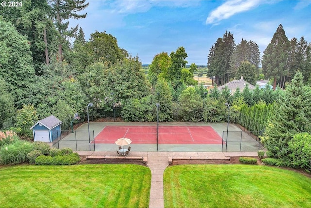 view of sport court with a lawn and basketball hoop