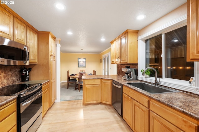 kitchen with light wood-type flooring, tasteful backsplash, stainless steel appliances, sink, and decorative light fixtures