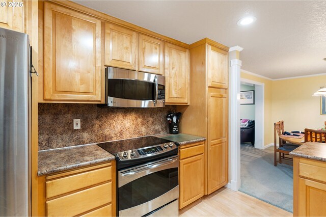 kitchen featuring light brown cabinets, crown molding, light wood-type flooring, and stainless steel appliances