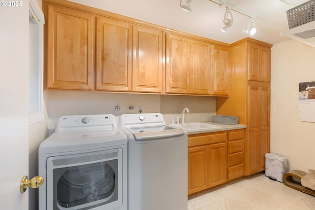 laundry area featuring cabinets, sink, and washer and dryer