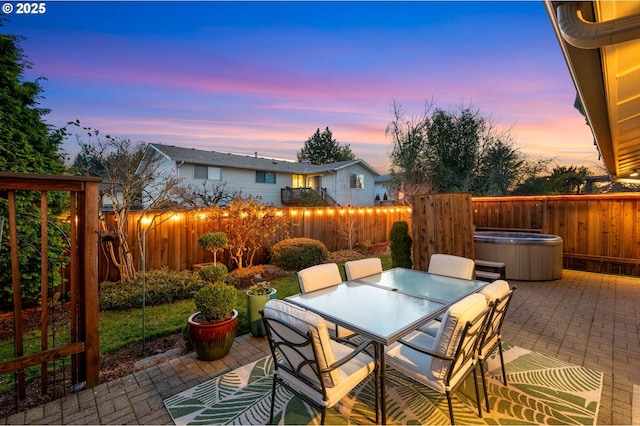 patio terrace at dusk with a hot tub