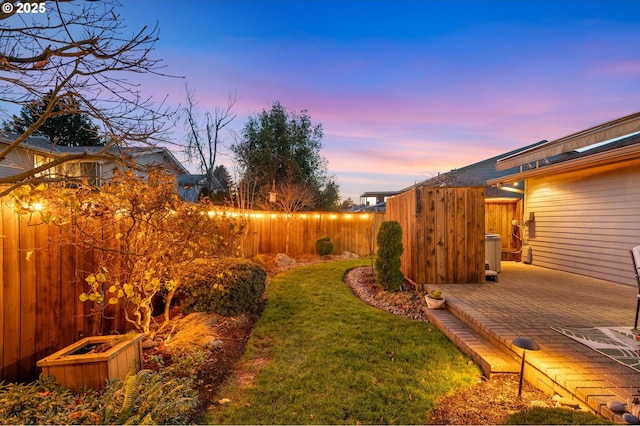 yard at dusk featuring a patio area