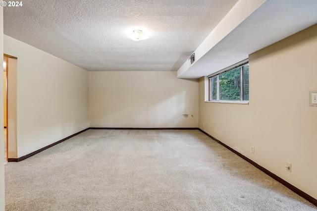 carpeted empty room with a textured ceiling