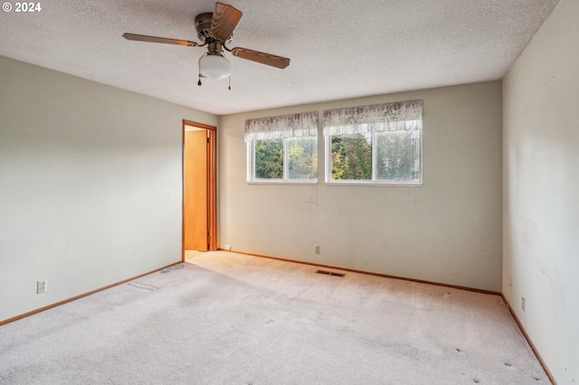 carpeted empty room featuring ceiling fan and a textured ceiling