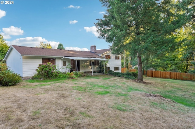 rear view of house with a yard