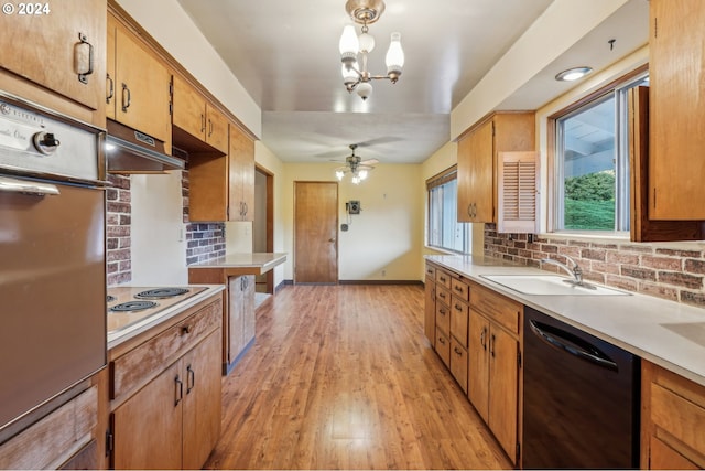 kitchen featuring pendant lighting, white electric cooktop, light hardwood / wood-style flooring, black dishwasher, and decorative backsplash