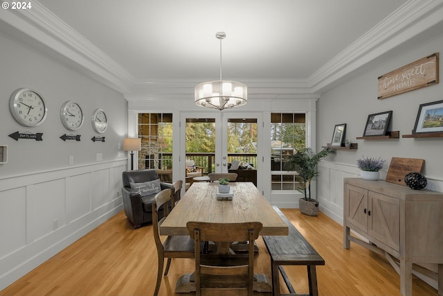 dining room featuring crown molding, light hardwood / wood-style flooring, and a notable chandelier