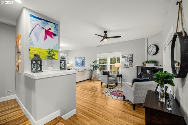 living room featuring hardwood / wood-style floors, a fireplace, and ceiling fan