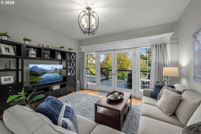 living room featuring an inviting chandelier, hardwood / wood-style floors, and french doors