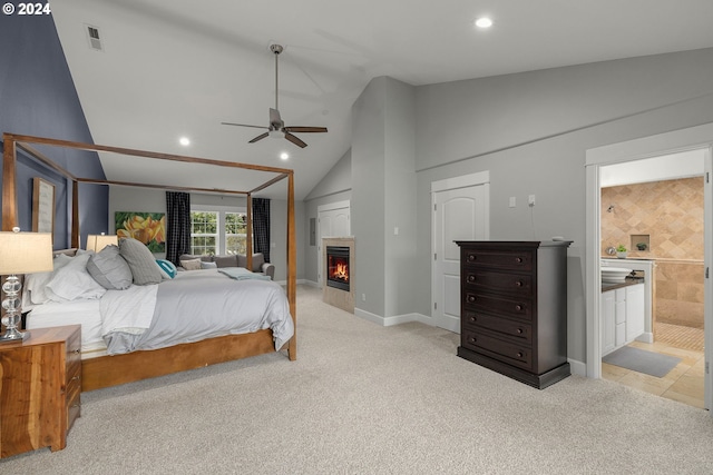 bedroom featuring ensuite bathroom, vaulted ceiling, light colored carpet, and ceiling fan