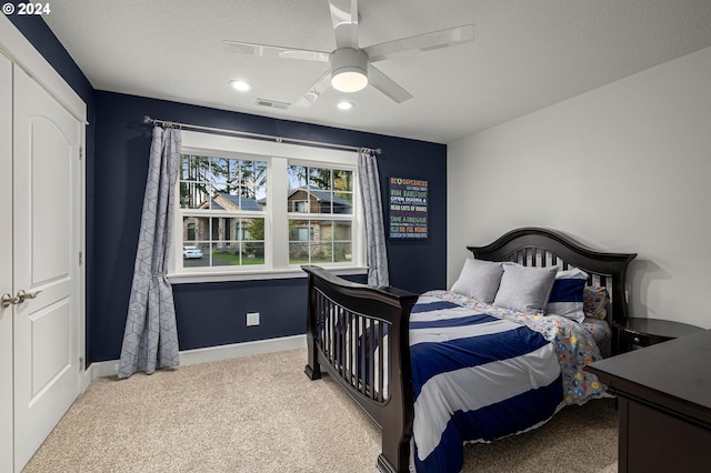 carpeted bedroom featuring ceiling fan and a closet