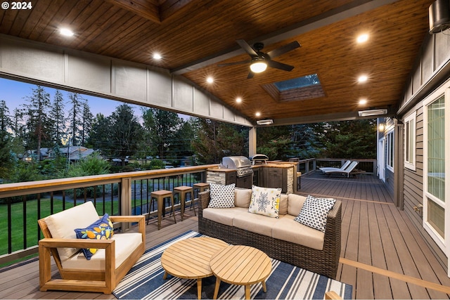 deck at dusk featuring ceiling fan and grilling area