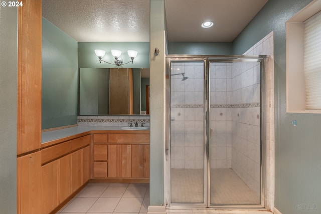 bathroom with tile patterned floors, a textured ceiling, an enclosed shower, decorative backsplash, and vanity