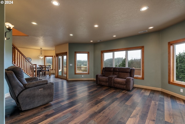 living room with a textured ceiling and dark wood-type flooring