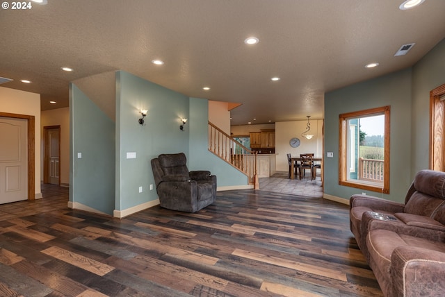 living room with dark wood-type flooring and a textured ceiling