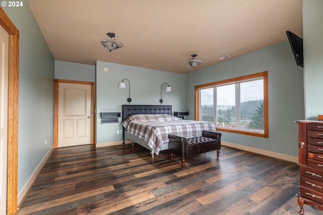 bedroom with dark hardwood / wood-style floors and a wall mounted AC