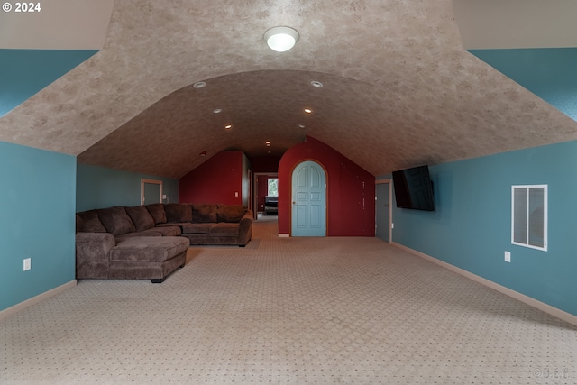 unfurnished living room featuring carpet, lofted ceiling, and brick ceiling