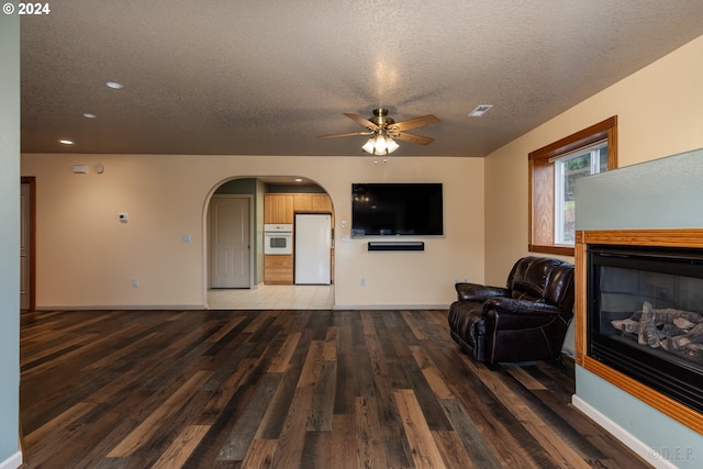 living room with wood-type flooring, a textured ceiling, and ceiling fan