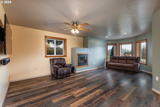 living room featuring a healthy amount of sunlight, dark hardwood / wood-style flooring, and a textured ceiling