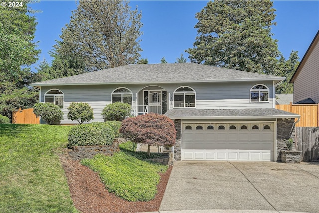 view of property with a garage and a front lawn