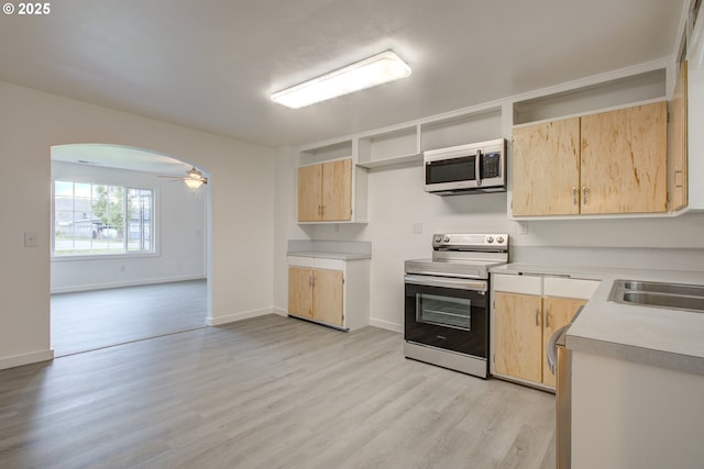 kitchen with sink, light brown cabinets, ceiling fan, light hardwood / wood-style flooring, and appliances with stainless steel finishes